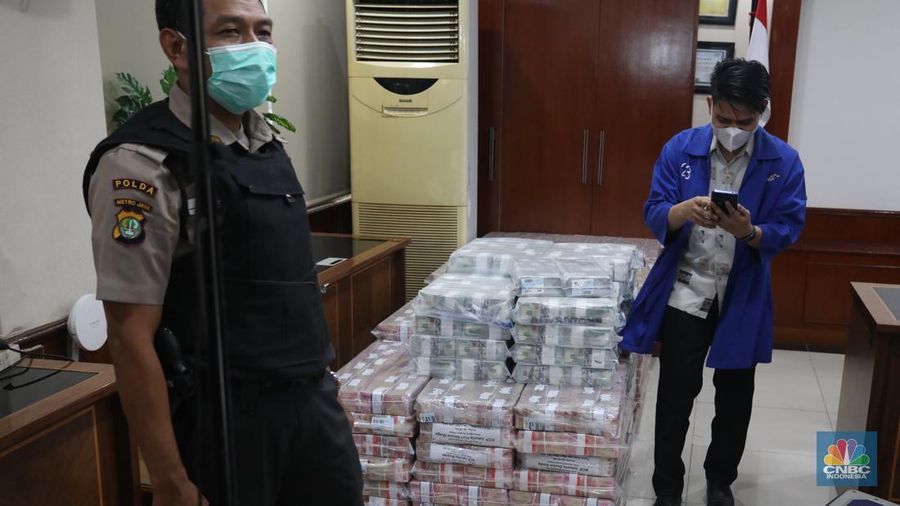 Petugas merapikan uang hasil korupsi PT Dulta Palma Group di Kejaksaan Agung, Jakarta, Selasa (30/8/2022). Rincian uang tunai yang disita adalah sebesar Rp 5,12 triliun. Selain itu, ada uang tunai yang disita sebesar US$ 11,4 juta dolar Amerika Serikat (AS) atau setara sekitar Rp 168,72 miliar jika menggunakan asumsi kurs Rp 14.800 per dolar AS. (CNBC Indonesia/Andrean Kristianto)