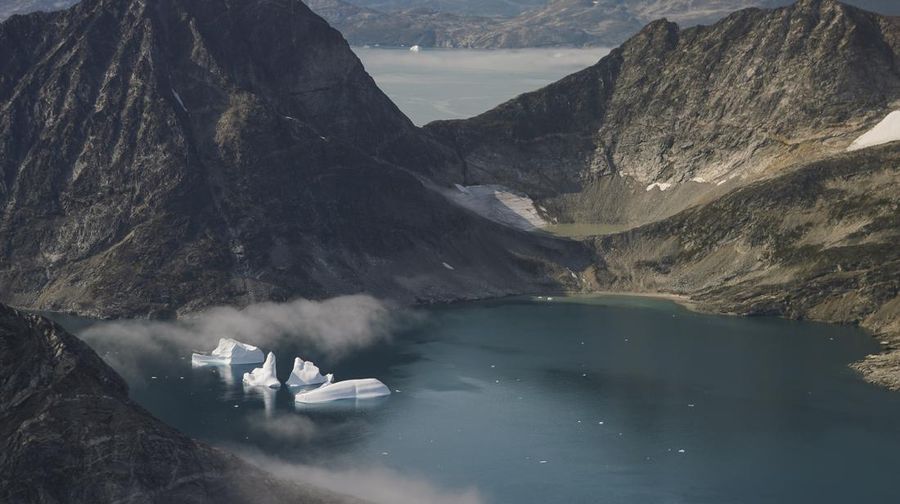 Sebuah kapal berlayar pada malam hari di sebelah gunung es besar di Greenland timur pada 15 Agustus 2019. (File Photo/AP/Mstyslav Chernov)