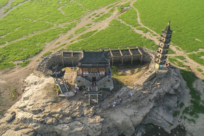 Sebuah kuil bersejarah di Pulau Luoxingdun, yang biasanya terendam di tengah Danau Poyang, kini terlihat dengan jelas. Pemandangan ini terjadi akibat kekeringan parah yang tengah berlangsung di China. (Visual China Group via Getty Images)