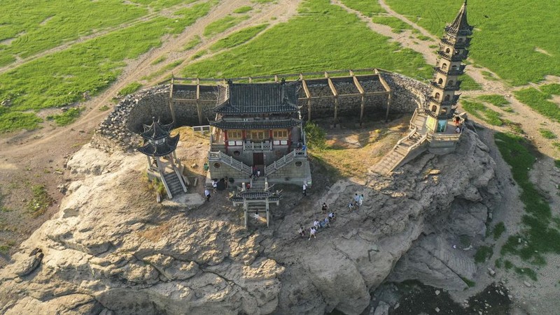 Sebuah kuil bersejarah di Pulau Luoxingdun, yang biasanya terendam di tengah Danau Poyang, kini terlihat dengan jelas. Pemandangan ini terjadi akibat kekeringan parah yang tengah berlangsung di China. (Visual China Group via Getty Images)