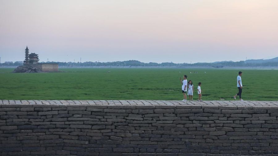 Sebuah kuil bersejarah di Pulau Luoxingdun, yang biasanya terendam di tengah Danau Poyang, kini terlihat dengan jelas. Pemandangan ini terjadi akibat kekeringan parah yang tengah berlangsung di China. (Visual China Group via Getty Images)