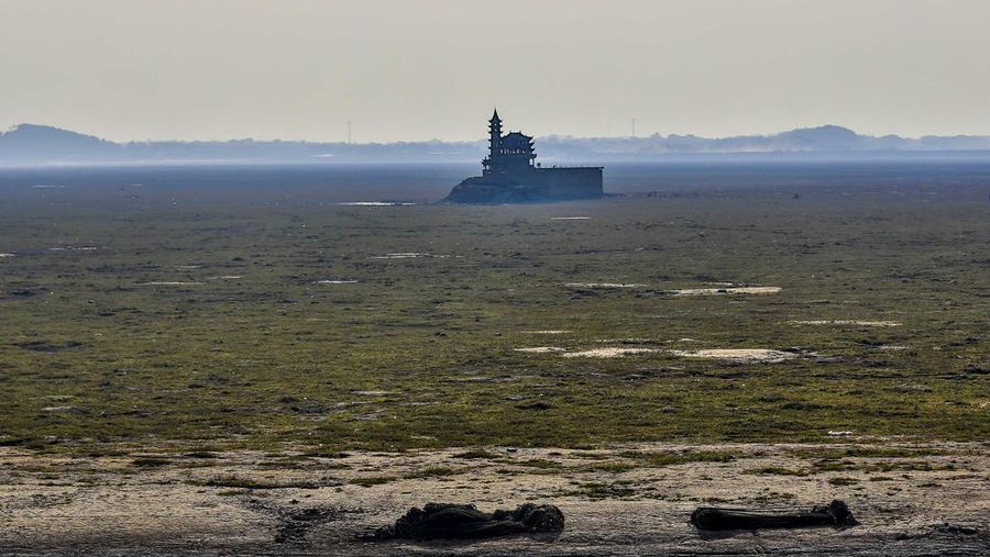 Sebuah kuil bersejarah di Pulau Luoxingdun, yang biasanya terendam di tengah Danau Poyang, kini terlihat dengan jelas. Pemandangan ini terjadi akibat kekeringan parah yang tengah berlangsung di China. (Visual China Group via Getty Images)