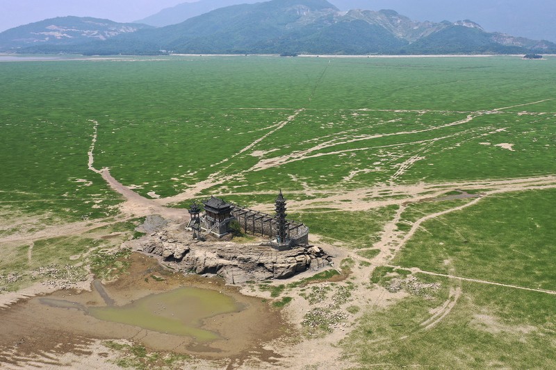 Sebuah kuil bersejarah di Pulau Luoxingdun, yang biasanya terendam di tengah Danau Poyang, kini terlihat dengan jelas. Pemandangan ini terjadi akibat kekeringan parah yang tengah berlangsung di China. (Visual China Group via Getty Images)