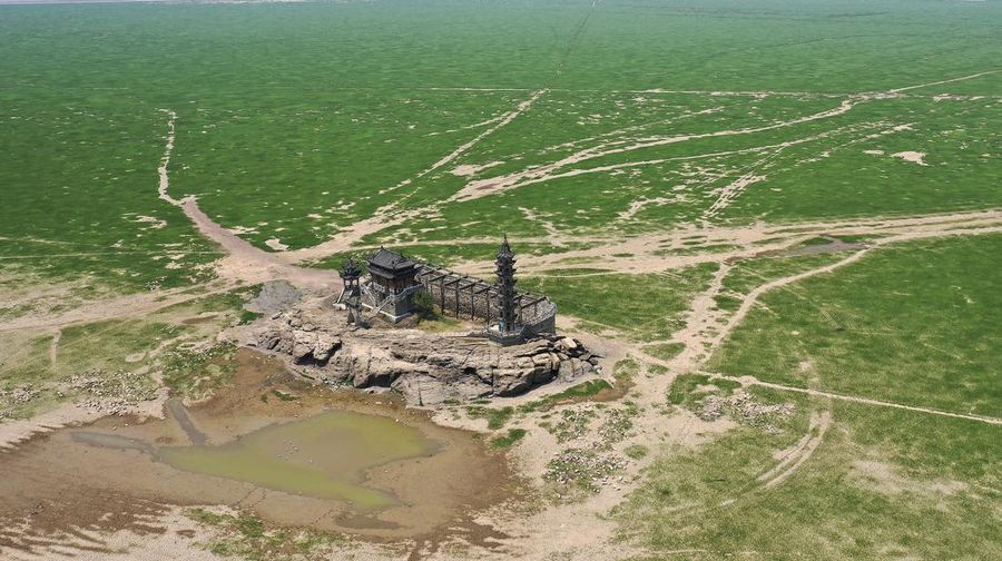Sebuah kuil bersejarah di Pulau Luoxingdun, yang biasanya terendam di tengah Danau Poyang, kini terlihat dengan jelas. Pemandangan ini terjadi akibat kekeringan parah yang tengah berlangsung di China. (Visual China Group via Getty Images)