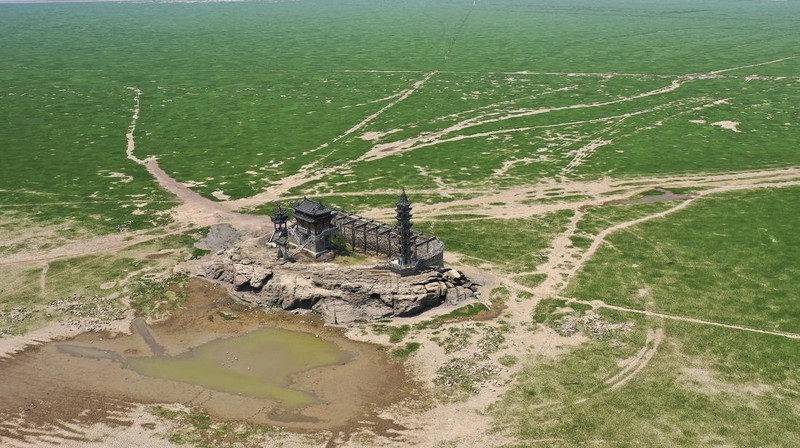 Sebuah kuil bersejarah di Pulau Luoxingdun, yang biasanya terendam di tengah Danau Poyang, kini terlihat dengan jelas. Pemandangan ini terjadi akibat kekeringan parah yang tengah berlangsung di China. (Visual China Group via Getty Images)