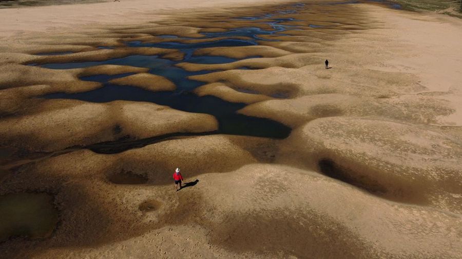 Pemandangan udara dari orang-orang yang berjalan di sepanjang lengan Sungai Parana yang hampir kering, yang ketinggian airnya mencapai titik terendah dalam sejarah, Brasil. (AFP via Getty Images/JUAN MABROMATA)