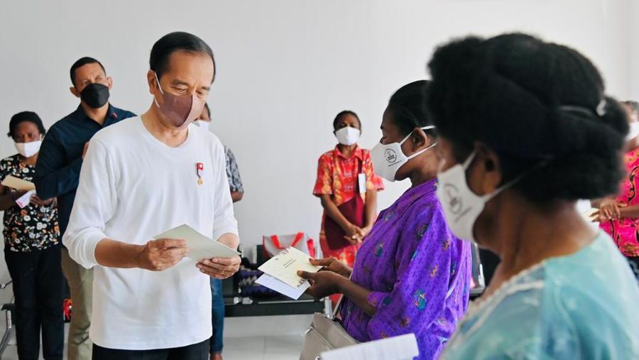 Presiden Joko Widodo didampingi Ibu Iriana Joko Widodo menyerahkan bantuan langsung tunai (BLT) bahan bakar minyak (BBM) untuk pertama kalinya di Kantor Pos Cabang Sentani, Kabupaten Jayapura, pada Rabu, 31 Agustus 2022. (Dok: Biro Pers Sekretariat Presiden)