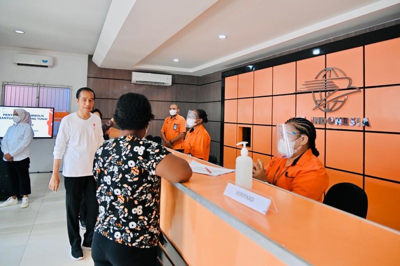Presiden Joko Widodo didampingi Ibu Iriana Joko Widodo menyerahkan bantuan langsung tunai (BLT) bahan bakar minyak (BBM) untuk pertama kalinya di Kantor Pos Cabang Sentani, Kabupaten Jayapura, pada Rabu, 31 Agustus 2022. (Dok: Biro Pers Sekretariat Presiden)