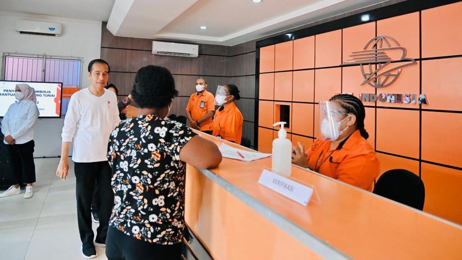 Presiden Joko Widodo didampingi Ibu Iriana Joko Widodo menyerahkan bantuan langsung tunai (BLT) bahan bakar minyak (BBM) untuk pertama kalinya di Kantor Pos Cabang Sentani, Kabupaten Jayapura, pada Rabu, 31 Agustus 2022. (Dok: Biro Pers Sekretariat Presiden)