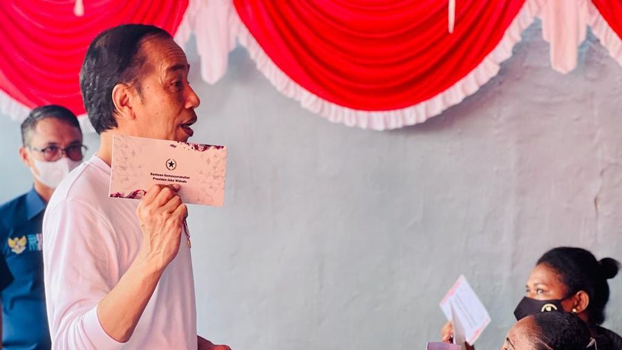Presiden Joko Widodo didampingi Ibu Iriana Joko Widodo menyerahkan bantuan langsung tunai (BLT) bahan bakar minyak (BBM) untuk pertama kalinya di Kantor Pos Cabang Sentani, Kabupaten Jayapura, pada Rabu, 31 Agustus 2022. (Dok: Biro Pers Sekretariat Presiden)