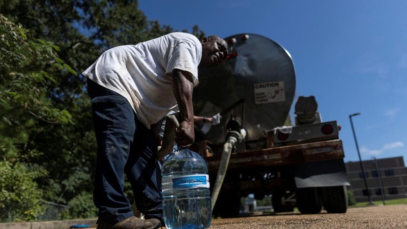 Orang-orang mengantri di lokasi distribusi air karena kota Jackson akan kehilangan air minum yang dapat diandalkan tanpa batas waktu setelah pompa di pabrik pengolahan air gagal, yang menyebabkan distribusi darurat air kemasan dan truk tangki untuk 180.000 orang, di Jackson, Mississippi , AS, 31 Agustus 2022. (REUTERS/CARLOS BARRIA)