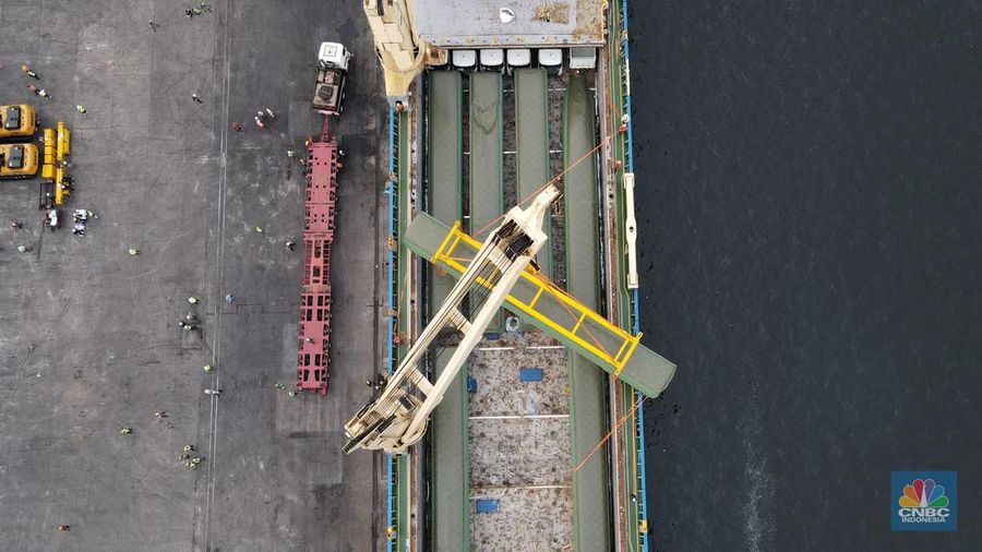 Pekerja dengan menggunakan alat berat melakukan bongkar muat Electric Multiple Unit (EMU) atau kereta untuk proyek Kereta Cepat Jakarta-Bandung (KCJB) yang tiba di Pelabuhan Tanjung Priok, Jumat (2/8/2022). (CNBC Indoensia/Andrean Kristianto)