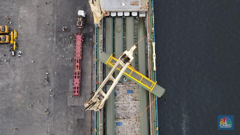 Pekerja dengan menggunakan alat berat melakukan bongkar muat Electric Multiple Unit (EMU) atau kereta untuk proyek Kereta Cepat Jakarta-Bandung (KCJB) yang tiba di Pelabuhan Tanjung Priok, Jumat (2/8/2022). (CNBC Indoensia/Andrean Kristianto)