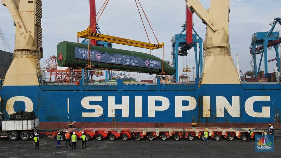 Pekerja dengan menggunakan alat berat melakukan bongkar muat Electric Multiple Unit (EMU) atau kereta untuk proyek Kereta Cepat Jakarta-Bandung (KCJB) yang tiba di Pelabuhan Tanjung Priok, Jumat (2/8/2022). (CNBC Indoensia/Andrean Kristianto)