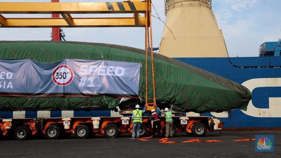 Pekerja dengan menggunakan alat berat melakukan bongkar muat Electric Multiple Unit (EMU) atau kereta untuk proyek Kereta Cepat Jakarta-Bandung (KCJB) yang tiba di Pelabuhan Tanjung Priok, Jumat (2/8/2022). (CNBC Indoensia/Andrean Kristianto)