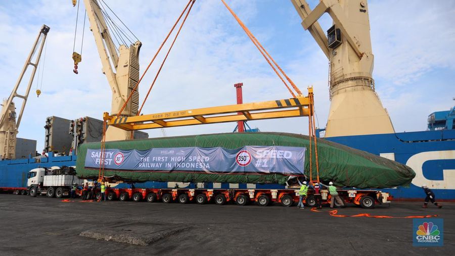 Pekerja dengan menggunakan alat berat melakukan bongkar muat Electric Multiple Unit (EMU) atau kereta untuk proyek Kereta Cepat Jakarta-Bandung (KCJB) yang tiba di Pelabuhan Tanjung Priok, Jumat (2/8/2022). (CNBC Indoensia/Andrean Kristianto)