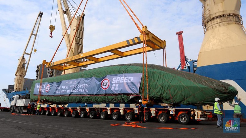 Pekerja dengan menggunakan alat berat melakukan bongkar muat Electric Multiple Unit (EMU) atau kereta untuk proyek Kereta Cepat Jakarta-Bandung (KCJB) yang tiba di Pelabuhan Tanjung Priok, Jumat (2/8/2022). (CNBC Indoensia/Andrean Kristianto)