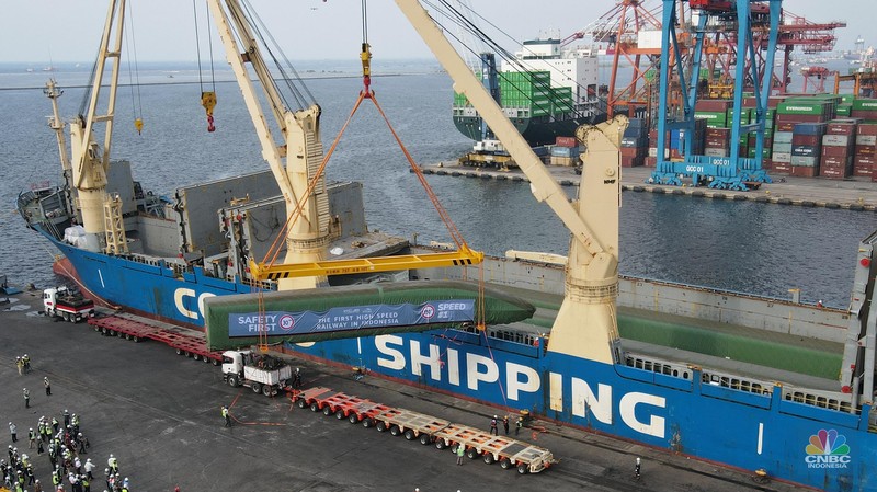Pekerja dengan menggunakan alat berat melakukan bongkar muat Electric Multiple Unit (EMU) atau kereta untuk proyek Kereta Cepat Jakarta-Bandung (KCJB) yang tiba di Pelabuhan Tanjung Priok, Jumat (2/8/2022). (CNBC Indoensia/Andrean Kristianto)
