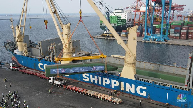 Pekerja dengan menggunakan alat berat melakukan bongkar muat Electric Multiple Unit (EMU) atau kereta untuk proyek Kereta Cepat Jakarta-Bandung (KCJB) yang tiba di Pelabuhan Tanjung Priok, Jumat (2/8/2022). (CNBC Indoensia/Andrean Kristianto)
