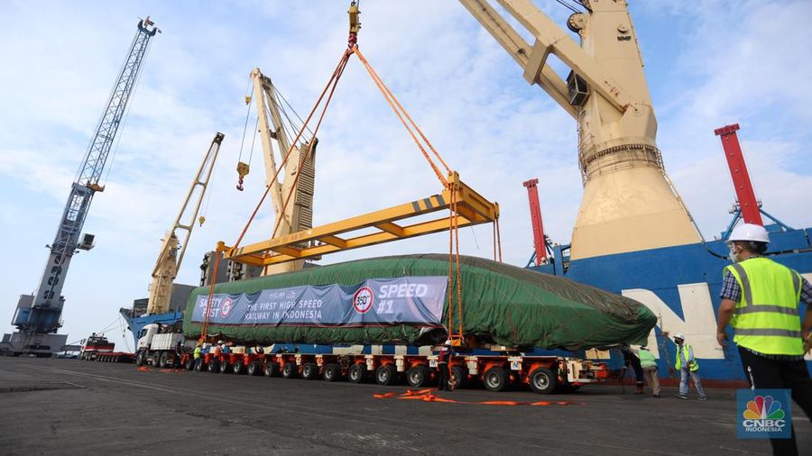 Pekerja dengan menggunakan alat berat melakukan bongkar muat Electric Multiple Unit (EMU) atau kereta untuk proyek Kereta Cepat Jakarta-Bandung (KCJB) yang tiba di Pelabuhan Tanjung Priok, Jumat (2/8/2022).  (CNBC Indoensia/Andrean Kristianto)