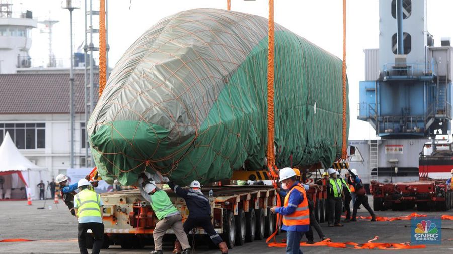Pekerja dengan menggunakan alat berat melakukan bongkar muat Electric Multiple Unit (EMU) atau kereta untuk proyek Kereta Cepat Jakarta-Bandung (KCJB) yang tiba di Pelabuhan Tanjung Priok, Jumat (2/8/2022). (CNBC Indoensia/Andrean Kristianto)