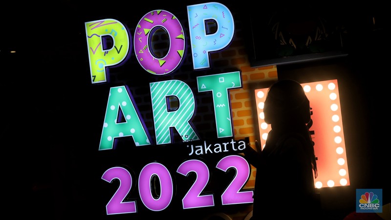 Pengunjung berfoto di salah satu instalasi seni yang dipamerkan dalam gelaran Pop Art Jakarta 2022 di Senayan Park, Jakarta. (CNBC Indonesia/Andrean Kristianto)