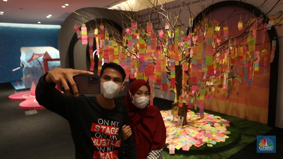 Pengunjung berfoto di salah satu instalasi seni yang dipamerkan dalam gelaran Pop Art Jakarta 2022 di Senayan Park, Jakarta. (CNBC Indonesia/Andrean Kristianto)