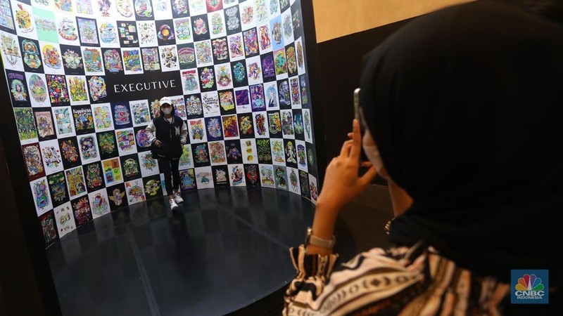 Pengunjung berfoto di salah satu instalasi seni yang dipamerkan dalam gelaran Pop Art Jakarta 2022 di Senayan Park, Jakarta. (CNBC Indonesia/Andrean Kristianto)