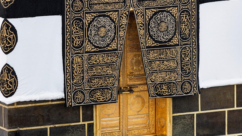 This picture taken on July 6, 2022 shows a close-up view of the Kiswa, the cloth used to cover the Kaaba, and the Kaaba's gold doors underneath, at the Grand Mosque in the Muslim holy city of Mecca during the annual Hajj pilgrimage. - One million fully vaccinated Muslims, including 850,000 from abroad, are allowed at this year's hajj in the city of Mecca, a big rise after two years of drastically curtailed numbers due to policies to stop the spread of infection. (Photo by AFP) (Photo by -/AFP via Getty Images)