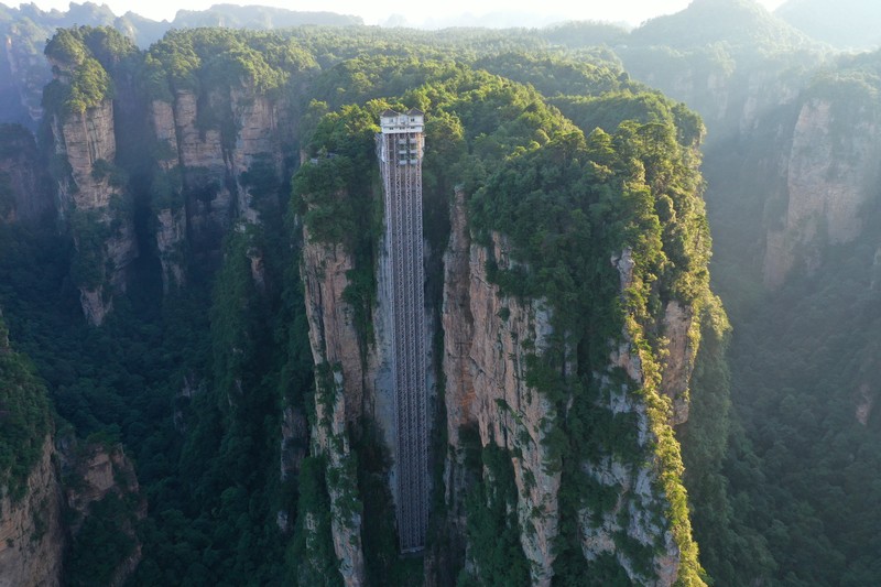 Aerial view of the Bailong Elevator built on a cliff in Zhangjiajie in south China's Hunan province Friday, July 26, 2019. The three glass elevators are 335 meters tall, and take tourists 326 m upward with 172 m on the vertical cliff and 154 m inside the mountain. It was claimed to be the tallest outdoor elevator in the world whn opened to the public by 2002. (Photo credit should read FANG DONGXU/Future Publishing via Getty Images)