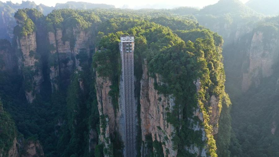 Aerial view of the Bailong Elevator built on a cliff in Zhangjiajie in south China's Hunan province Friday, July 26, 2019. The three glass elevators are 335 meters tall, and take tourists 326 m upward with 172 m on the vertical cliff and 154 m inside the mountain. It was claimed to be the tallest outdoor elevator in the world whn opened to the public by 2002. (Photo credit should read FANG DONGXU/Future Publishing via Getty Images)