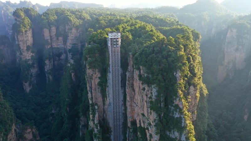 Aerial view of the Bailong Elevator built on a cliff in Zhangjiajie in south China's Hunan province Friday, July 26, 2019. The three glass elevators are 335 meters tall, and take tourists 326 m upward with 172 m on the vertical cliff and 154 m inside the mountain. It was claimed to be the tallest outdoor elevator in the world whn opened to the public by 2002. (Photo credit should read FANG DONGXU/Future Publishing via Getty Images)