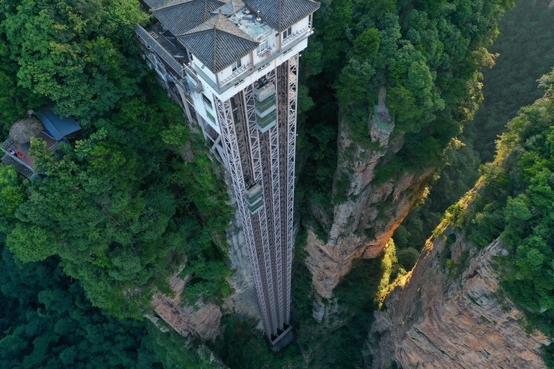 1158351748 Aerial view of the Bailong Elevator built on a cliff in Zhangjiajie in south China's Hunan province Friday, July 26, 2019. The three glass elevators are 335 meters tall, and take tourists 326 m upward with 172 m on the vertical cliff and 154 m inside the mountain. It was claimed to be the tallest outdoor elevator in the world whn opened to the public by 2002. (Photo credit should read FANG DONGXU/Future Publishing via Getty Images)