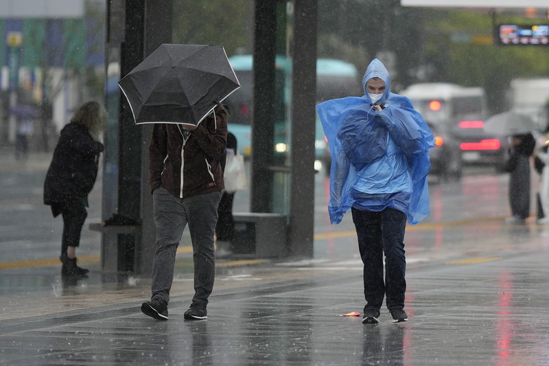 Topan Hinnamnor di pulau Jeju, Korea Selatan Seorang pria berjalan melewati angin kencang yang disebabkan oleh topan Hinnamnor di pulau Jeju, Korea Selatan, Senin (5/9/2022), (Yonhap via REUTERS)