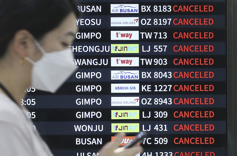Topan Hinnamnor di pulau Jeju, Korea Selatan Seorang pria berjalan melewati angin kencang yang disebabkan oleh topan Hinnamnor di pulau Jeju, Korea Selatan, Senin (5/9/2022), (Yonhap via REUTERS)