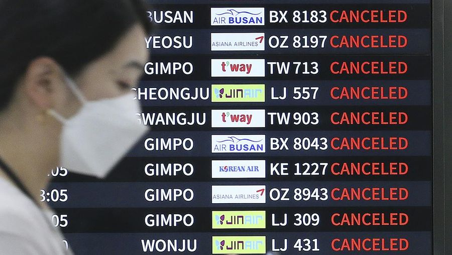 Seorang pria berjalan melewati angin kencang yang disebabkan oleh topan Hinnamnor di pulau Jeju, Korea Selatan, Senin (5/9/2022), (Yonhap via REUTERS)