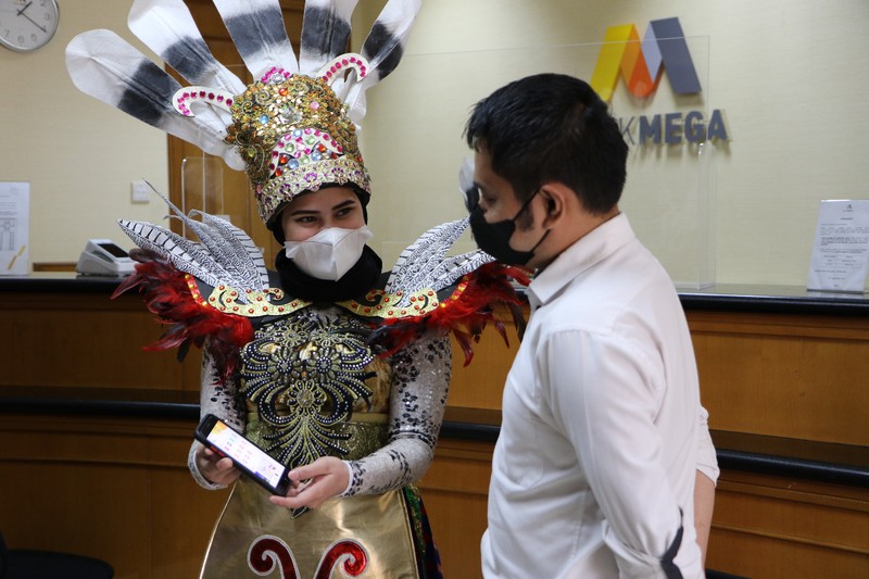 Petugas Customer Service Bank Mega memakai kostum adat Suku Dayak Petugas Customer Service Bank Mega memakai kostum adat Suku Dayak saat memberikan pelayanan m banking kepada salah seorang nasabah di KCP Jakarta Cinere, Kota Depok, Jawa Barat, Senin (5/9/2022). Sehubungan dengan pelaksanaan Hari Pelanggan Nasional, karyawan Bank Mega di seluruh Kantor Cabang dan Kantor Cabang Pembantu sengaja memakai kostum dengan beragam tema guna memberikan pengalaman yang berbeda kepada para nasabah yang berkunjung. (Dok. Bank Mega)