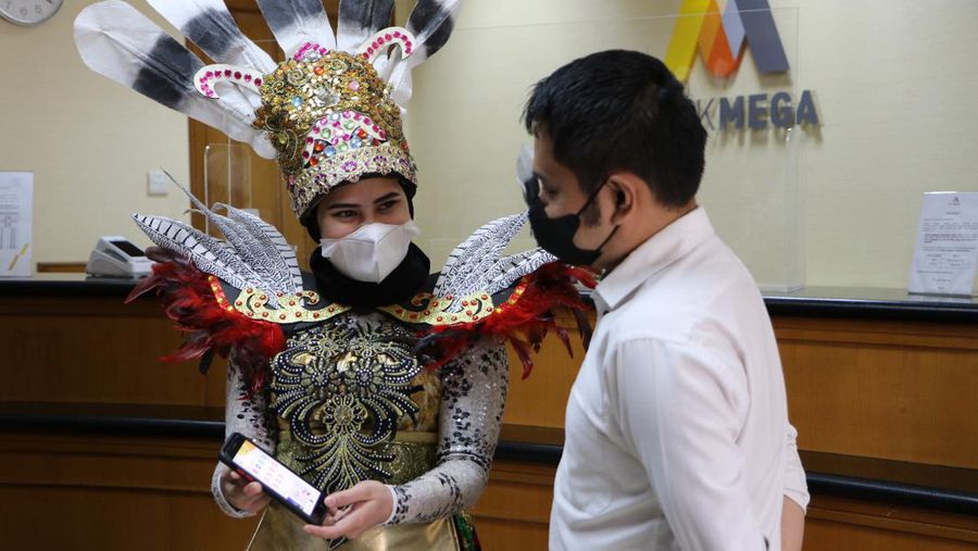 Petugas Customer Service Bank Mega memakai kostum adat Suku Dayak