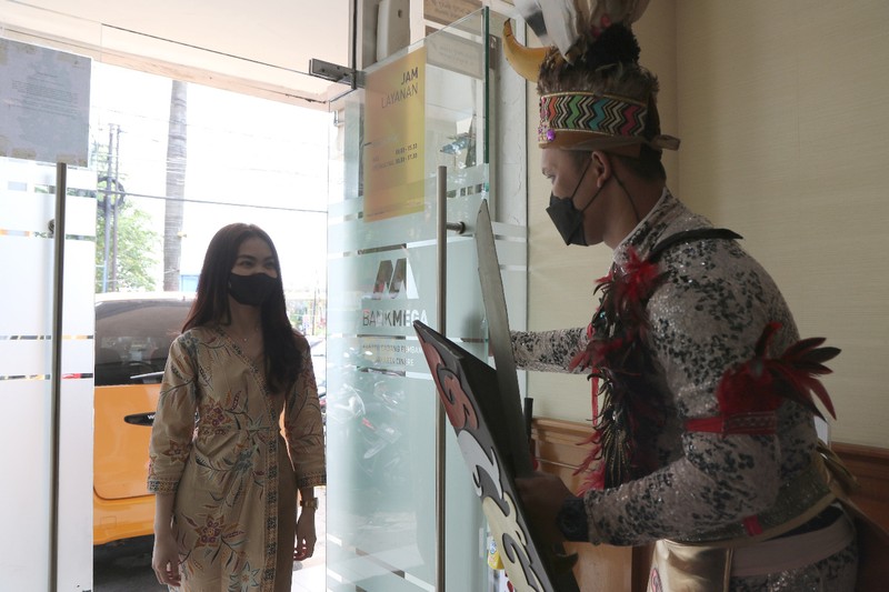 Petugas Customer Service Bank Mega memakai kostum adat Suku Dayak Petugas Customer Service Bank Mega memakai kostum adat Suku Dayak saat memberikan pelayanan m banking kepada salah seorang nasabah di KCP Jakarta Cinere, Kota Depok, Jawa Barat, Senin (5/9/2022). Sehubungan dengan pelaksanaan Hari Pelanggan Nasional, karyawan Bank Mega di seluruh Kantor Cabang dan Kantor Cabang Pembantu sengaja memakai kostum dengan beragam tema guna memberikan pengalaman yang berbeda kepada para nasabah yang berkunjung. (Dok. Bank Mega)
