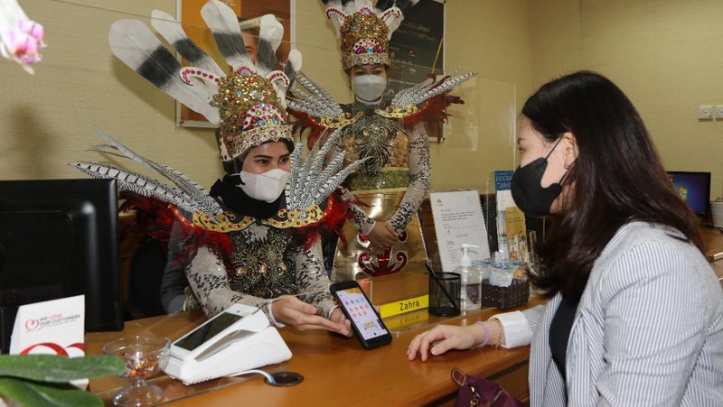 Petugas Customer Service Bank Mega memakai kostum adat Suku Dayak saat memberikan pelayanan m banking kepada salah seorang nasabah di KCP Jakarta Cinere, Kota Depok, Jawa Barat, Senin (5/9/2022). Sehubungan dengan pelaksanaan Hari Pelanggan Nasional, karyawan Bank Mega di seluruh Kantor Cabang dan Kantor Cabang Pembantu sengaja memakai kostum dengan beragam tema guna memberikan pengalaman yang berbeda kepada para nasabah yang berkunjung. (Dok. Bank Mega)