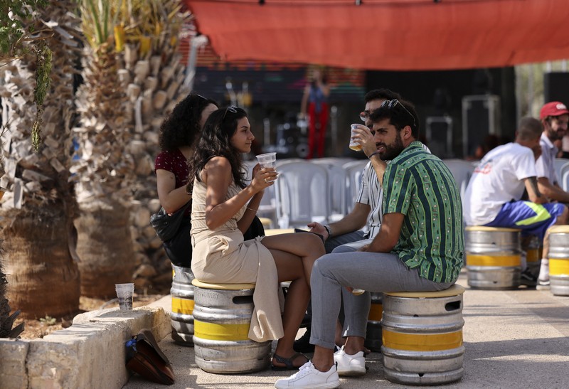 Seorang bartender melayani pengunjung pada festival bir tahunan Oktoberfest di desa Taybeh di desa Taybeh, sebelah timur kota Ramallah Tepi Barat, Palestina, Jumat (2/92/2022). Bir Taybeh dibuat dari buah anggur yang tumbuh di kebun anggur dekat Kota Birzeit, West Bank, sekitar 10 kilometer timur laut Ramallah. Bir Taybeh diseduh dalam jumlah kecil, tanpa menggunakan bahan pengawet atau gula tambahan. Taybeh Brewing Company didirikan oleh Nadim Khoury dan keluarganya pada 1994 di West Bank, Palestina dan kini diteruskan oleh seorang wanita bernama Madees Khoury, (Photo by ABBAS MOMANI/AFP via Getty Images).