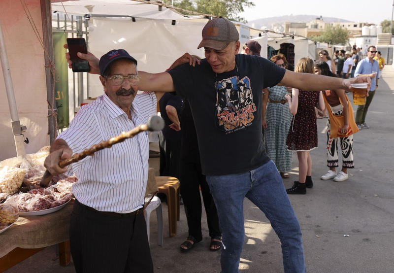 Bir Halal Palestina Taybeh Seorang bartender melayani pengunjung pada festival bir tahunan Oktoberfest di desa Taybeh di desa Taybeh, sebelah timur kota Ramallah Tepi Barat, Palestina, Jumat (2/92/2022). Bir Taybeh dibuat dari buah anggur yang tumbuh di kebun anggur dekat Kota Birzeit, West Bank, sekitar 10 kilometer timur laut Ramallah. Bir Taybeh diseduh dalam jumlah kecil, tanpa menggunakan bahan pengawet atau gula tambahan. Taybeh Brewing Company didirikan oleh Nadim Khoury dan keluarganya pada 1994 di West Bank, Palestina dan kini diteruskan oleh seorang wanita bernama Madees Khoury, (Photo by ABBAS MOMANI/AFP via Getty Images).