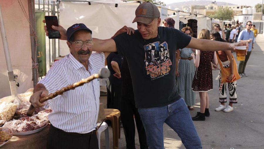 Seorang bartender melayani pengunjung pada festival bir tahunan Oktoberfest di desa Taybeh di desa Taybeh, sebelah timur kota Ramallah Tepi Barat, Palestina, Jumat (2/92/2022). Bir Taybeh dibuat dari buah anggur yang tumbuh di kebun anggur dekat Kota Birzeit, West Bank, sekitar 10 kilometer timur laut Ramallah. Bir Taybeh diseduh dalam jumlah kecil, tanpa menggunakan bahan pengawet atau gula tambahan. Taybeh Brewing Company didirikan oleh Nadim Khoury dan keluarganya pada 1994 di West Bank, Palestina dan kini diteruskan oleh seorang wanita bernama Madees Khoury, (Photo by ABBAS MOMANI/AFP via Getty Images).