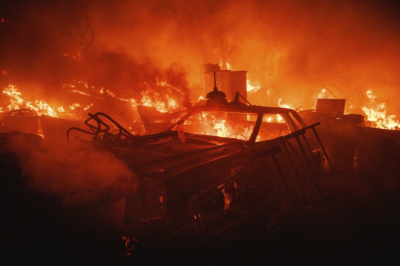 Kebakaran Hutan Fairview di Riverside County, California, AS Sebuah pesawat pemadam kebakaran bekerja memadamkan api yang telah mendekati rumah selama Kebakaran hutan Fairview dekat Hemet, California di Riverside County, AS, Rabu (7/9/2022). Kebakaran hutan akibat gelombang panas di California, Amerika Serikat (AS), terus meluas dengan cepat. Kejadian tersebut menyebabkan dua orang tewas dan ribuan orang dievakuasi untuk mengungsi. (Photo by PATRICK T. FALLON/AFP via Getty Images)