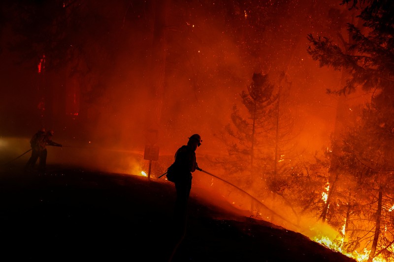 Kebakaran Hutan Fairview di Riverside County, California, AS Sebuah pesawat pemadam kebakaran bekerja memadamkan api yang telah mendekati rumah selama Kebakaran hutan Fairview dekat Hemet, California di Riverside County, AS, Rabu (7/9/2022). Kebakaran hutan akibat gelombang panas di California, Amerika Serikat (AS), terus meluas dengan cepat. Kejadian tersebut menyebabkan dua orang tewas dan ribuan orang dievakuasi untuk mengungsi. (Photo by PATRICK T. FALLON/AFP via Getty Images)