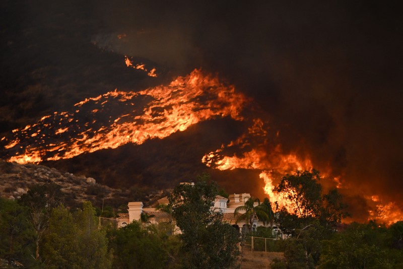 Kebakaran Hutan Fairview di Riverside County, California, AS Sebuah pesawat pemadam kebakaran bekerja memadamkan api yang telah mendekati rumah selama Kebakaran hutan Fairview dekat Hemet, California di Riverside County, AS, Rabu (7/9/2022). Kebakaran hutan akibat gelombang panas di California, Amerika Serikat (AS), terus meluas dengan cepat. Kejadian tersebut menyebabkan dua orang tewas dan ribuan orang dievakuasi untuk mengungsi. (Photo by PATRICK T. FALLON/AFP via Getty Images)