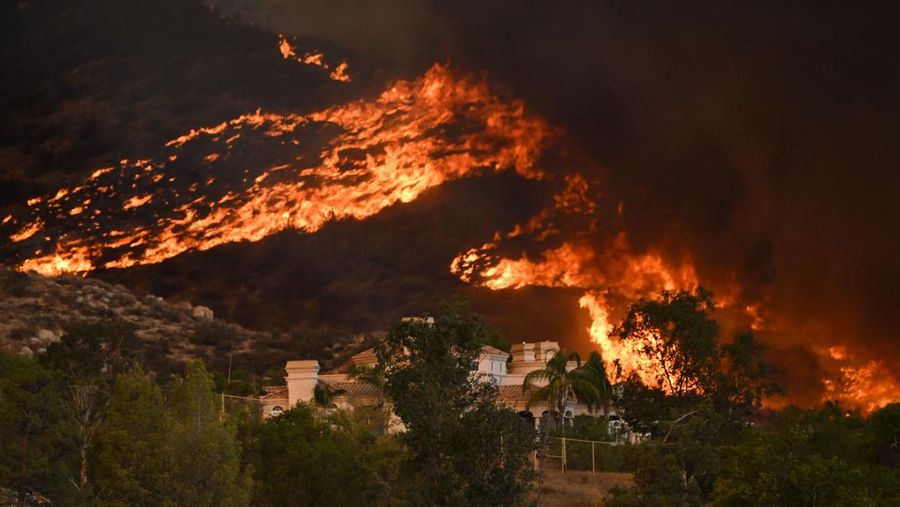 Gumpalan asap membubung saat api mendekati sebuah pemukiman selama Kebakaran hutan (Fairview) dekat Hemet, California di Riverside County, AS, Rabu (7/9/2022). Kebakaran hutan akibat gelombang panas di California, Amerika Serikat (AS), terus meluas dengan cepat. Kejadian tersebut menyebabkan dua orang tewas dan ribuan orang dievakuasi untuk mengungsi.  (Photo by PATRICK T. FALLON/AFP via Getty Images)