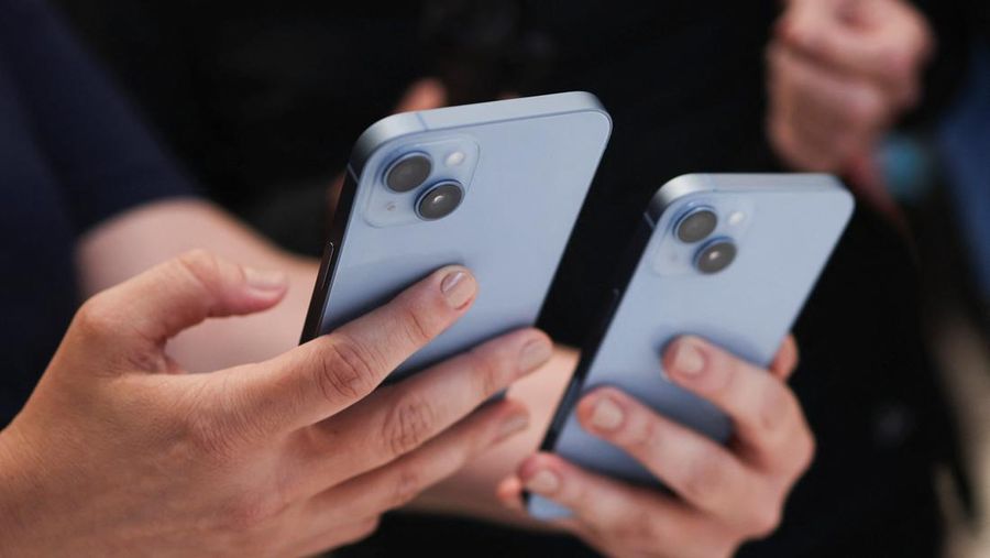 Seorang pengunjung memegang iPhone 14 baru di acara Apple di kantor pusat mereka di Cupertino, California, Amerika Serikat, Rabu (7/9/2022). (REUTERS/Carlos Barria)