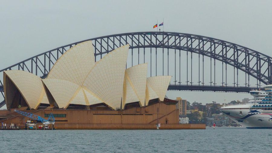 Bendera Australia dan Aborigin berkibar setengah tiang di Harbour Bridge di Sydney, Jumat (9/9/2022). Bendera setengah tiang tersebut sebagai penghormatan atas meninggalnya Ratu Elizabeth II, pemimpin terlama dalam sejarah Inggris dalam usia 96 tahun. (Photo by ROBERT WALLACE/AFP via Getty Images)
