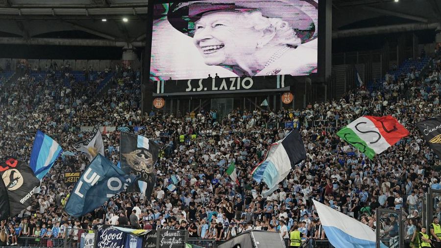 Potret Ratu Inggris Elizabeth II ditampilkan di layar raksasa setelah pengumuman meninggalnya, sebelum dimulainya pertandingan sepak bola leg pertama Grup F Liga Eropa UEFA antara SS Lazio dan Feyenoord Rotterdam di stadion Olimpiade di Roma, Kamis (8/9/2022). (Photo by VINCENZO PINTO/AFP via Getty Images)